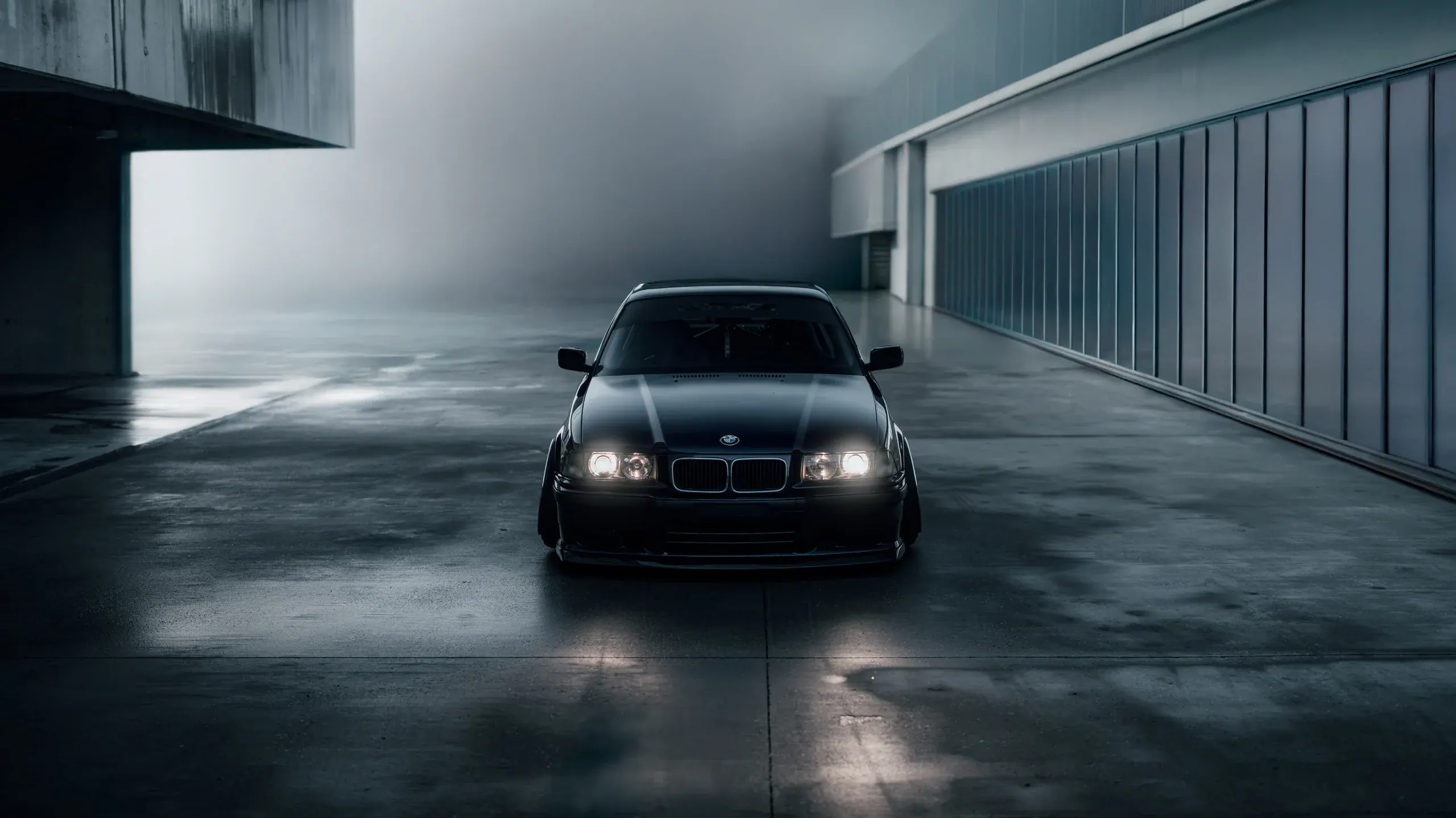 BMW E36 driving towards the camera through mist and humid air.