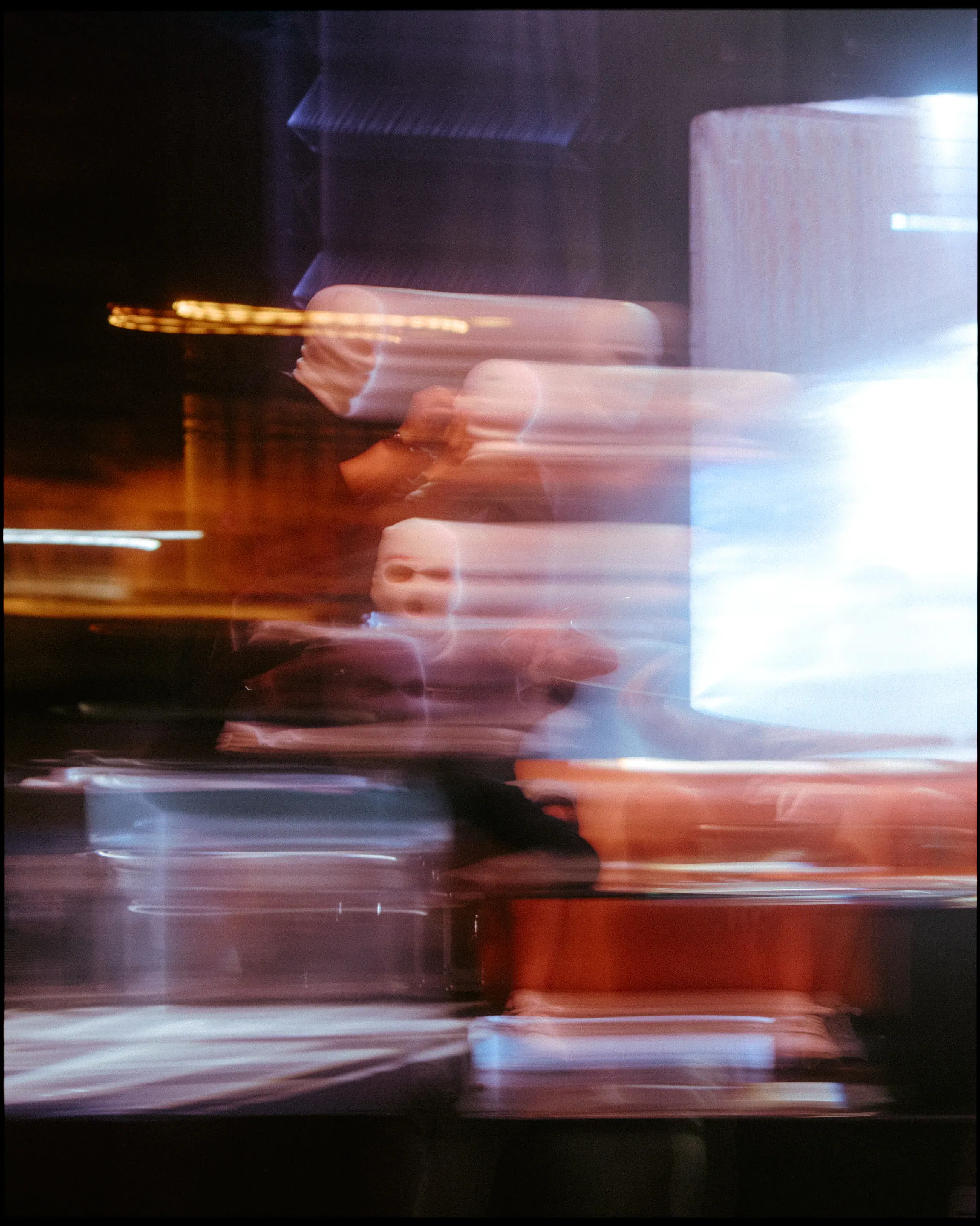 Blurred figure crossing in front of a screen and lights during the night-time part of the event.
